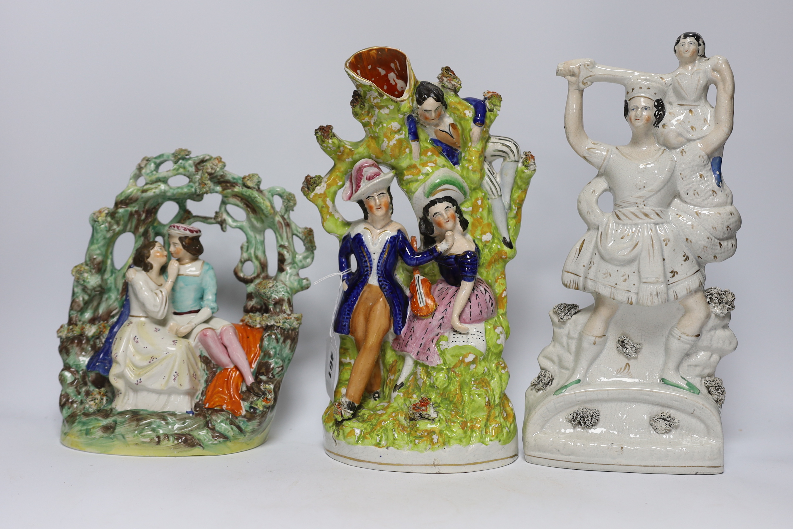 Seven Staffordshire flat backs, including a gentleman on horse back, two seated lovers, a similar pair of King Charles Spaniels, and a pair of Staffordshire style cats, tallest 32cm